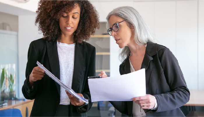 Two business women look over documents together