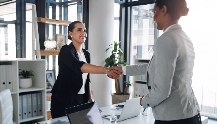 A business woman and business man shake hands