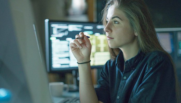 A woman looks at a computer monitor