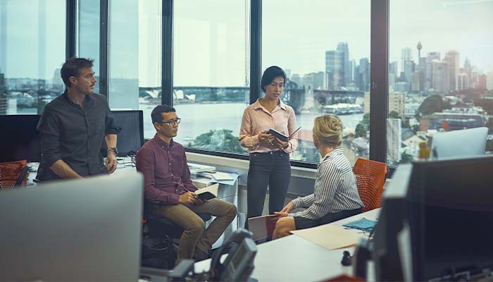 A group of co-workers sitting at their desks and talking